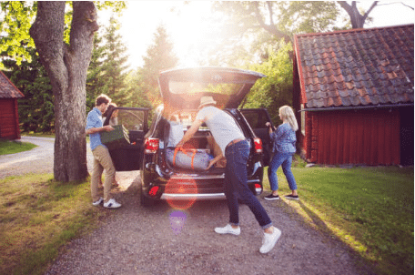 famille qui charge la voiture avant le départ en vacances